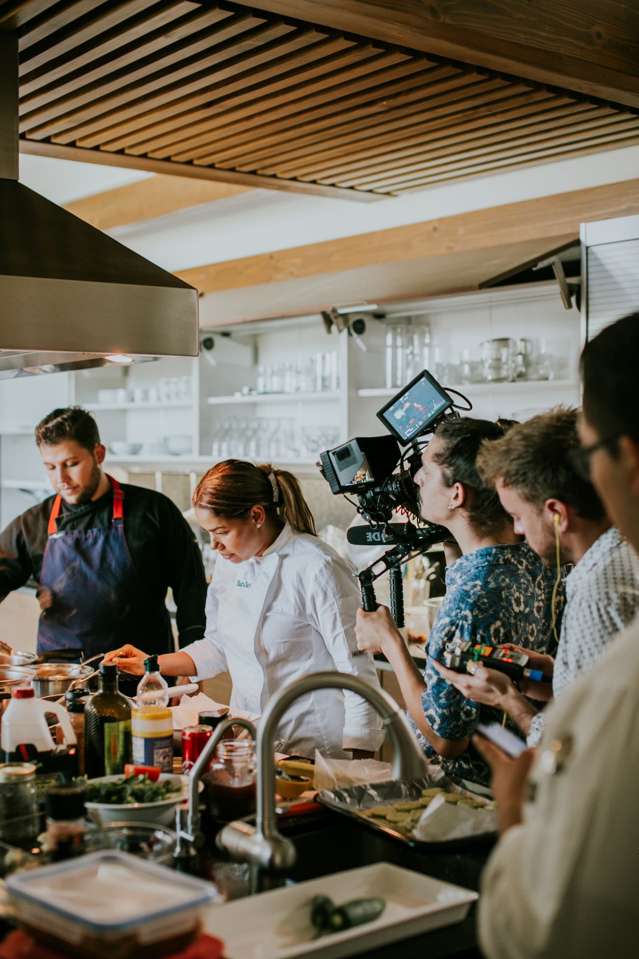Professional video crew filming a culinary demonstration in a modern kitchen