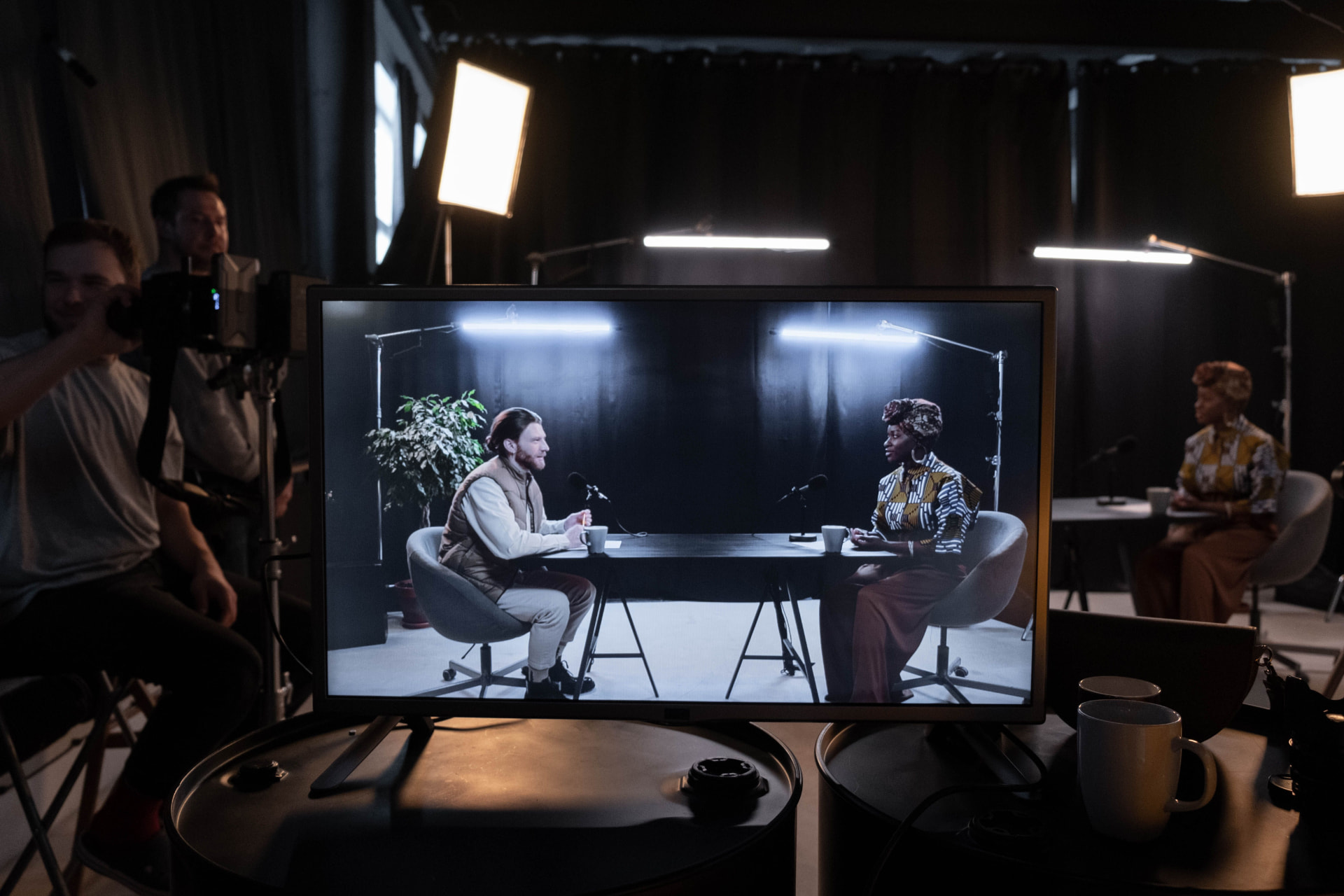 Documentary interview setup with subject framed on a production monitor in a dimly lit room